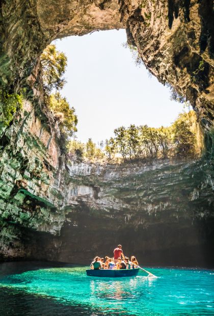 People travel with wooden boat in famous cave of Kefalonia